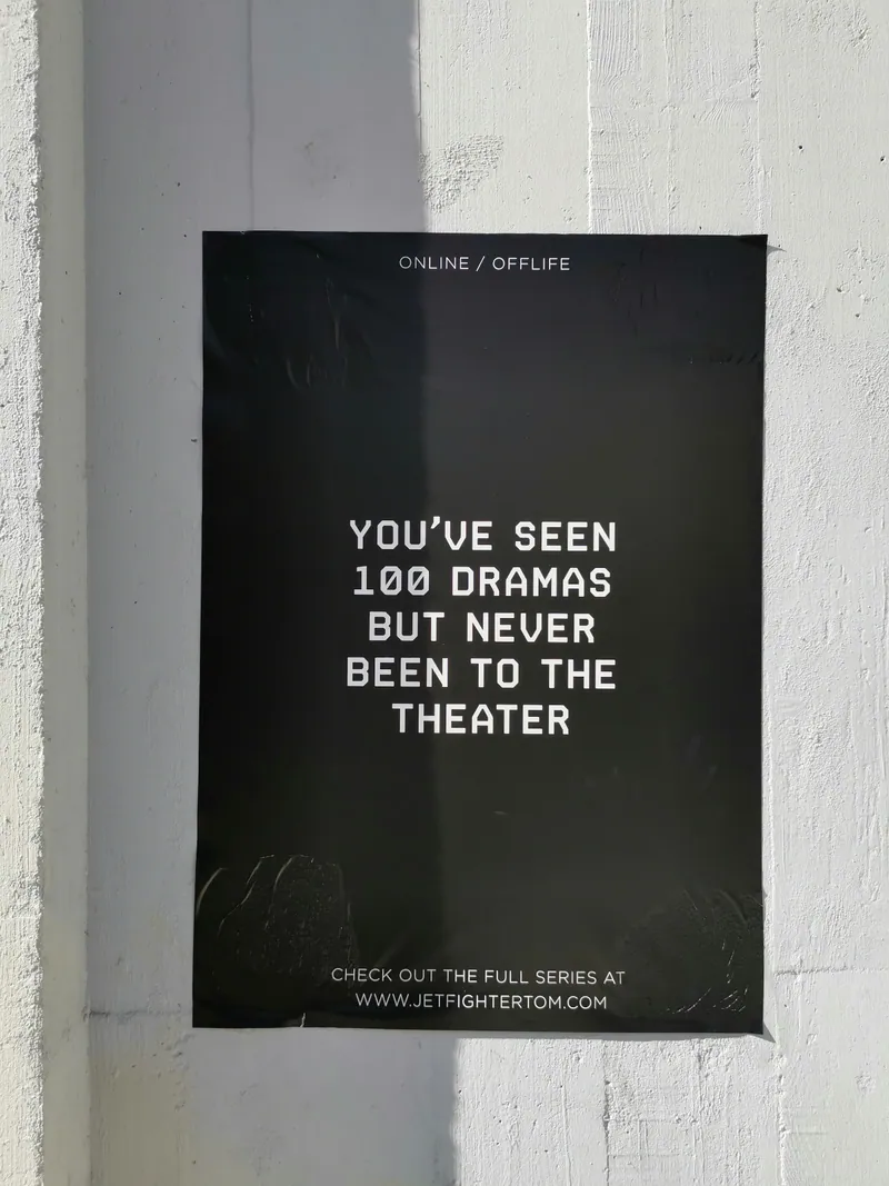 Affiche typographique noire collée sur un mur blanc