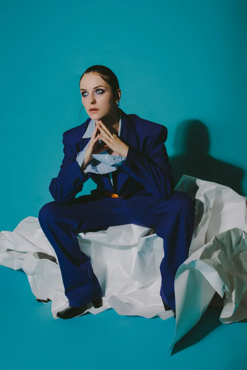Portrait de mode en costume bleu sur un fond turquoise