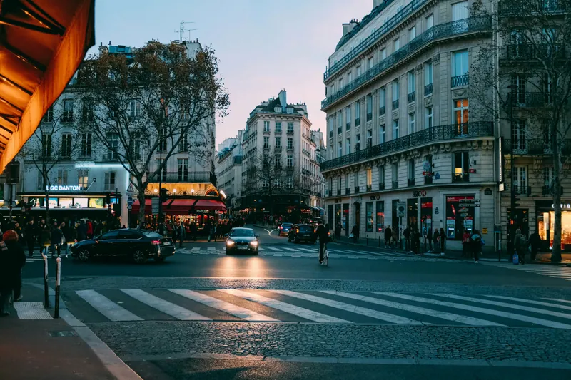 Carrefour parisien et passage piéton à la tombée du jour