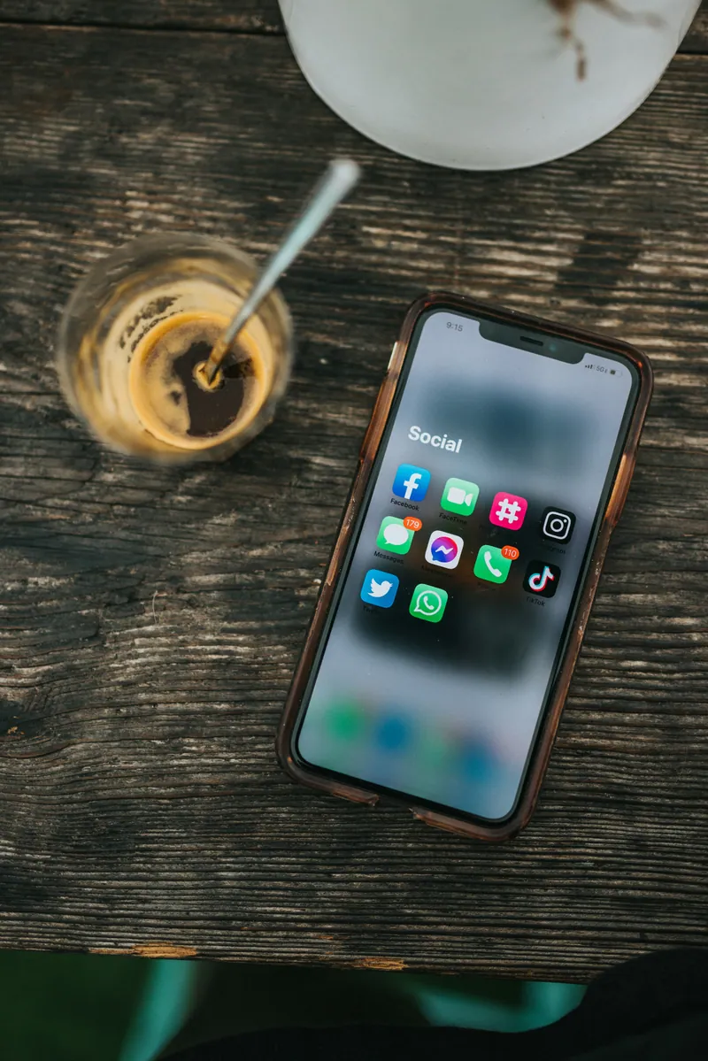 Smartphone posé sur une table en bois à côté d'un café