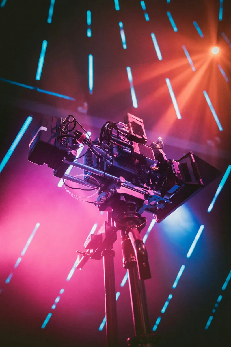 Caméra de tournage vue en contre-plongée sous des néons roses